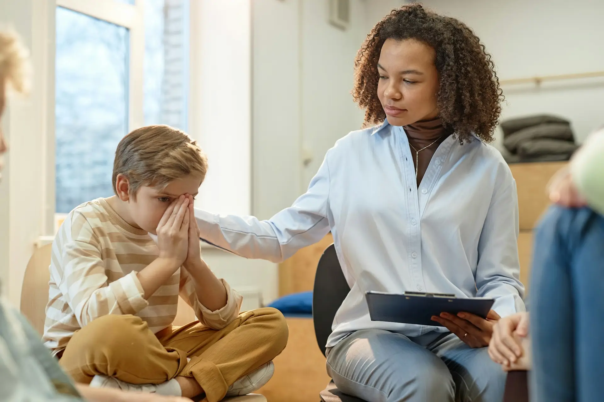 Female Therapist Comforting Troubled Little Boy